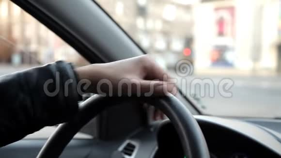 女孩坐在车里转动汽车的方向盘视频的预览图
