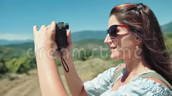特写肖像女旅行者用相机拍摄大自然视频的预览图