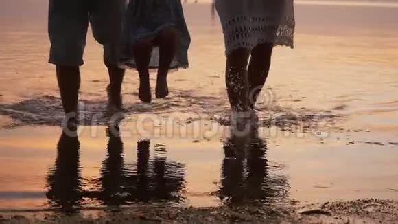 女人男人和孩子沿着海岸走父亲带着女儿过水家庭假日慢慢慢慢视频的预览图