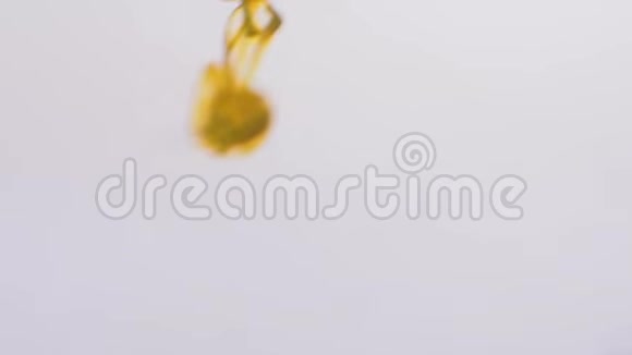 黄色油漆在水中的近距离飞溅美丽的烟熏效果分布在水中的墨滴柔和的烟熏视频的预览图