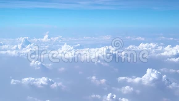 美丽的白云在蓝天的清晨透过飞机观看视频的预览图