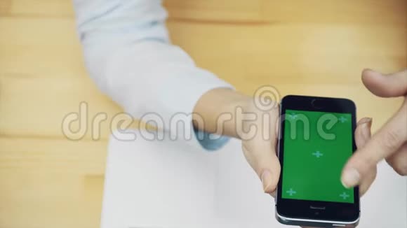 女性用手触摸智能手机使用电脑和设备在办公桌上进行通信的设备视频的预览图