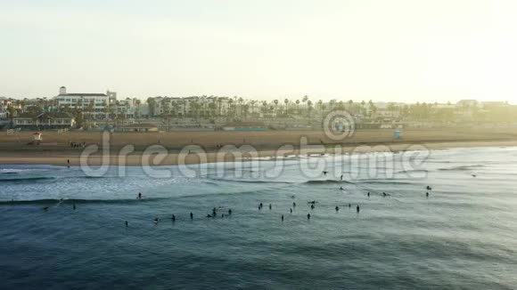 清晨黎明时分在汉廷顿海滩等待海浪的冲浪者视频的预览图