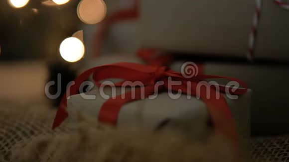 带有红丝带的圣诞礼品盒背景是明亮的灯光视频的预览图