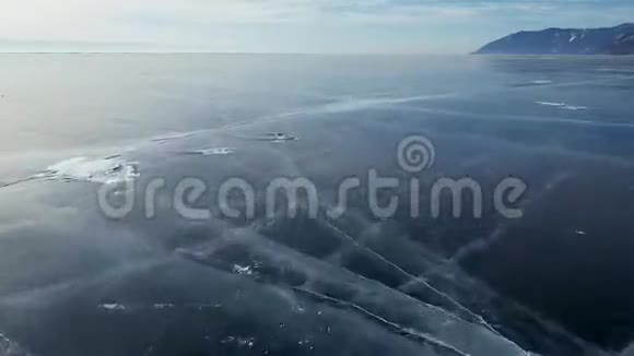 空中透视美丽的深蓝冰纹理冰冻贝加尔湖表面与钻捕获视频的预览图