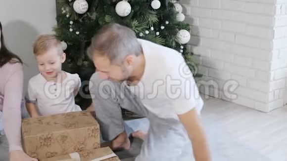 一家人在圣诞树和礼物附近玩视频的预览图
