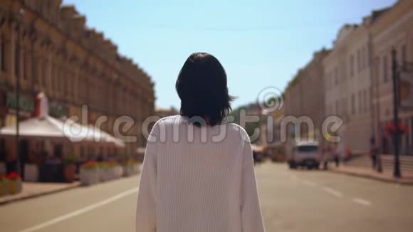 穿着白色套头衫和黑色裙子的布鲁内特女士走路视频的预览图