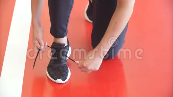健身女孩在健身健身馆做鞋带然后再跑步锻炼视频的预览图