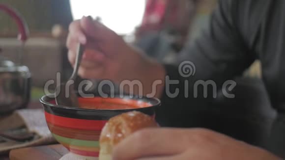 一双面目全非的手在餐馆里吃汤一个男人吃健康的饭午餐健康的生活方式视频的预览图