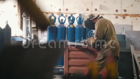 穿着防护服的工人在工厂焊接一个部件视频的预览图
