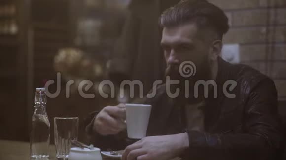 帅哥坐在咖啡馆里喝咖啡视频的预览图