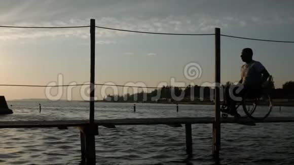 晚上坐轮椅的人靠水走路在空中飞翔海鸥视频的预览图