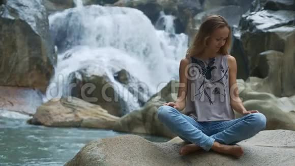 石头上的少女欣赏大自然与瀑布视频的预览图