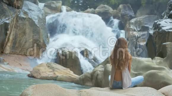 荷花中的少女对瀑布和岩石的栖息视频的预览图