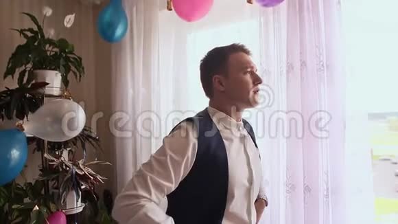 准备新郎参加婚礼新郎在一个有球的房间里穿上节日背心视频的预览图