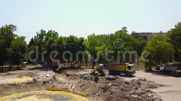 黄挖机挖基坑地面用斗搬运货物至货车地面准备工作视频的预览图