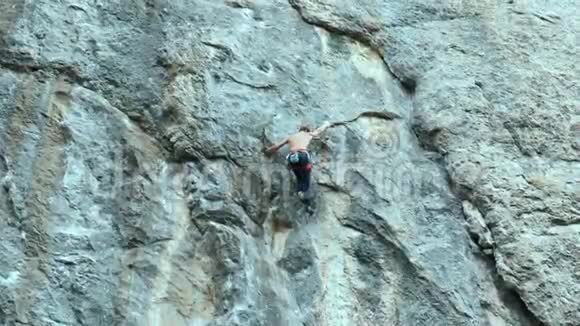 强壮的肌肉男攀岩者在户外运动路线上攀登垂直悬崖视频的预览图