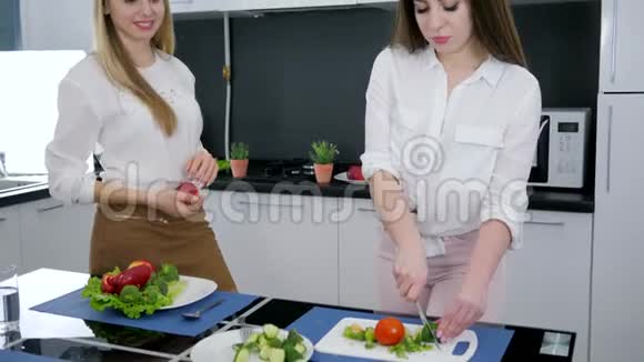 准备午餐在厨房过得愉快女朋友在做色拉时大笑视频的预览图