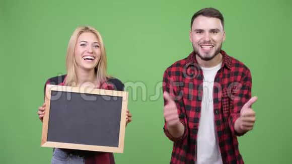 年轻夫妇举着黑板一起竖起大拇指视频的预览图