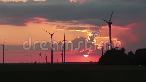 风力涡轮机在日落时在田野里旋转视频的预览图