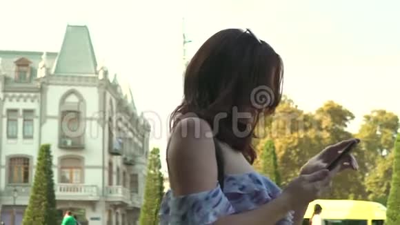 女人用手机走路说话慢动作相机稳定器拍摄视频的预览图