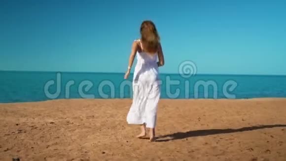 穿着白色裙子的快乐女孩奔向大海欢欣鼓舞视频的预览图