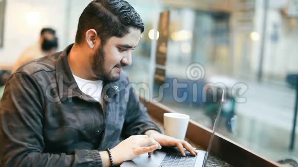 年轻的黑发拉丁西班牙裔的家伙正在使用电脑咖啡馆自由职业者工作空间录像片段视频的预览图