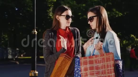 两位年轻女性成功购物后体验他们互相展示他们的购买视频的预览图