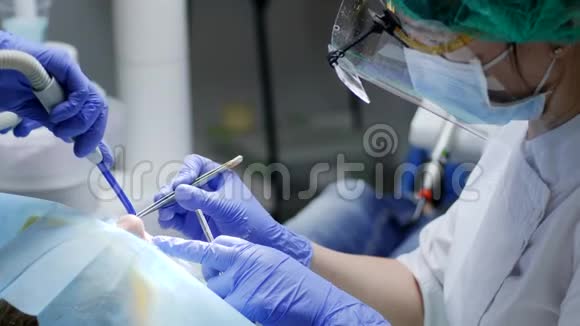 医疗诊所医生用牙镊子戴口罩手里拿着镜子在病人口里做手术视频的预览图