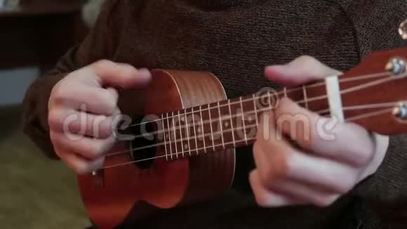 玩四弦琴的年轻人的手视频的预览图