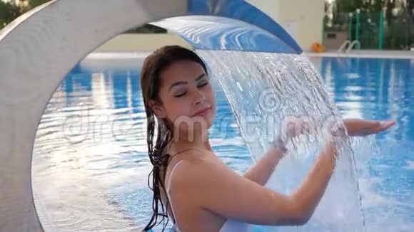 夏季游泳池装饰瀑布下的女游泳衣放松视频的预览图