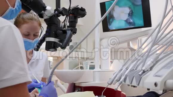 现代医院的病人护理医生用牙科显微镜和屏幕做手术视频的预览图