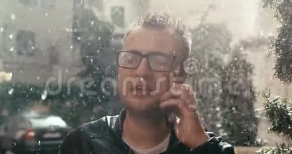 戴眼镜的恶人在雨中通过手机说话时对某人大喊大叫的肖像4K录像视频的预览图