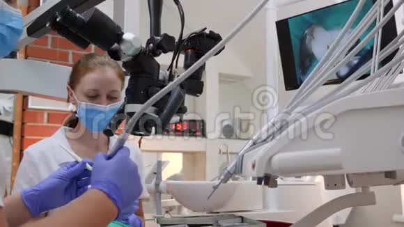 戴着橡胶手套的男人在显微镜下观察旁边是戴着医用口罩的女医生视频的预览图
