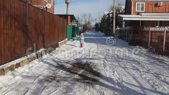 冬天一个小孩在雪地街上跑来跑去视频的预览图