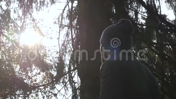 特写胡子男日落时观看户外自然在森林里旅行视频的预览图