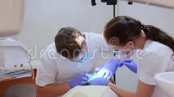 戴着医疗手套和口罩的牙医在诊所做躺卧手术视频的预览图