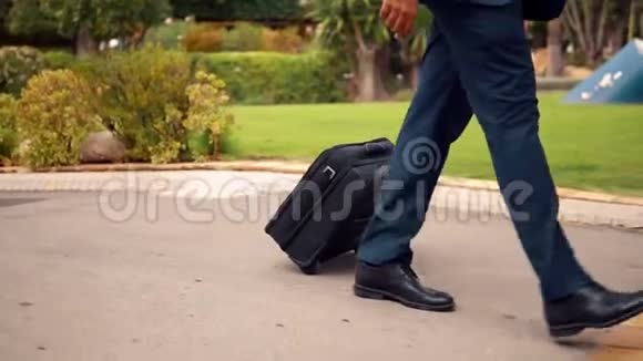 印度商人穿着蓝色西装带着旅行袋或手提箱走路视频的预览图
