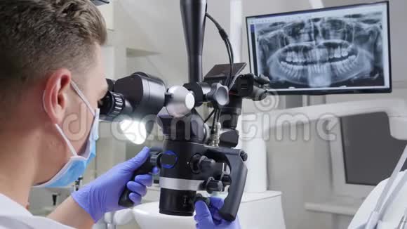 男医生在临床上通过牙科显微镜观察牙齿现代医学技术视频的预览图