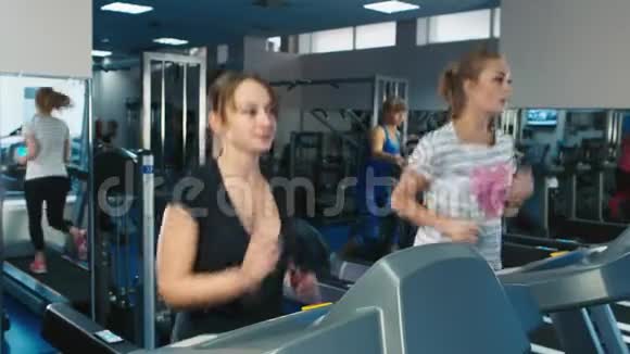 两个女人在健身房跑步机上跑步视频的预览图