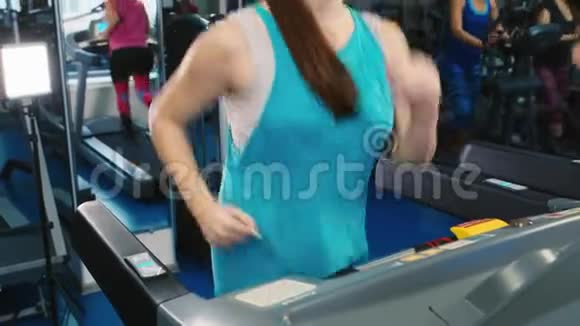 有魅力的女人在跑步机上跑步微笑着视频的预览图