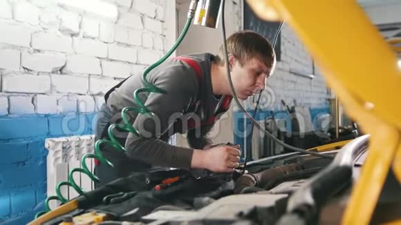 修理工检查汽车引擎盖内的电气修理发动机舱视频的预览图