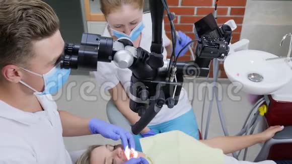 专业医生和护士用双眼显微镜进行妇女躺卧手术视频的预览图