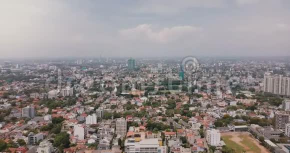 在斯里兰卡的科伦坡市上空向后飞行的无人机令人惊叹的亚洲城市景观天际线的空中全景视频的预览图