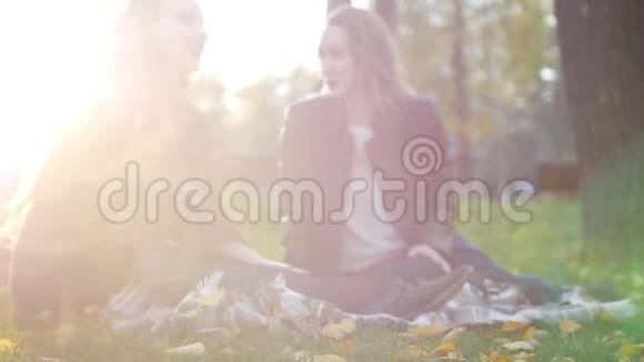 秋天公园的女孩坐在毯子上聊天视频的预览图