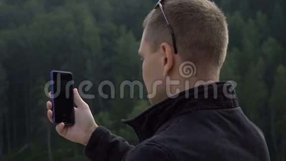 年轻的游客带着智能手机拍照大自然令人惊叹视频的预览图