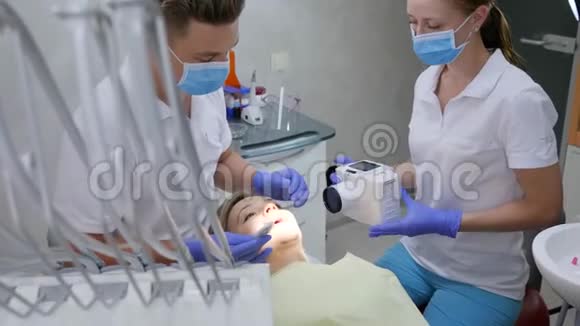 配备特殊牙科摄像机的医生用现代化设备拍摄女病人口腔照片视频的预览图
