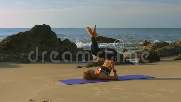 金发女郎在蔚蓝的海洋海滩上改变瑜伽池视频的预览图