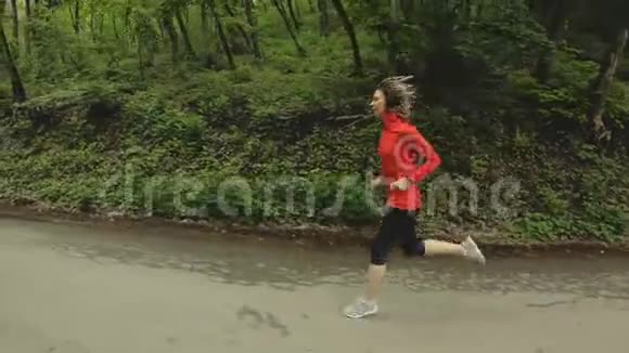 跑步女孩金发女孩在夏天的森林里做户外运动侧视慢镜头广角视频的预览图