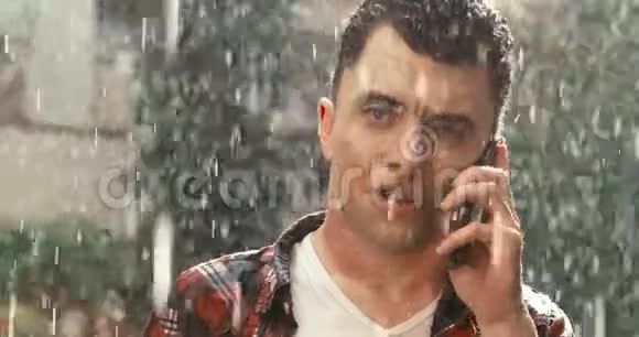 雨中在手机上说话的快乐情感男人的肖像惊讶的情绪4K录像视频的预览图